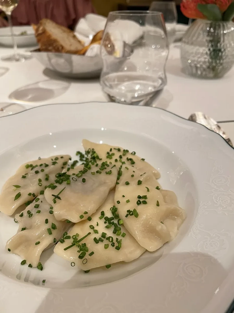 Piatto di pierogi cotti guarniti con erba cipollina, ricetta tradizionale polacca